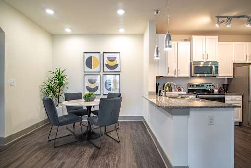 A kitchen with a dining table and chairs.