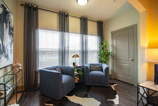 A living room with two grey couches and a cowhide rug.