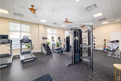 A gym with treadmills, weights, and exercise equipment.