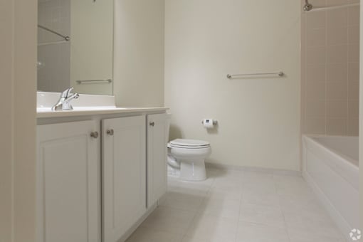 A white bathroom with a toilet, sink, and bathtub.