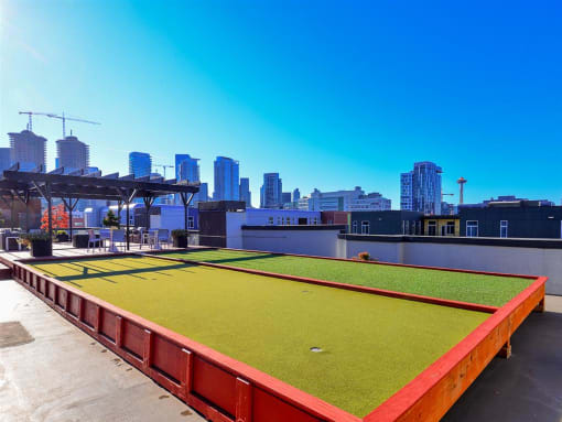 a soccer field on the roof of a building with a cityscape in the background