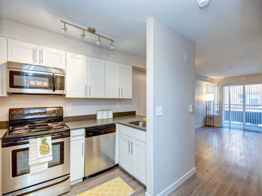 a kitchen with white cabinets and stainless steel appliances