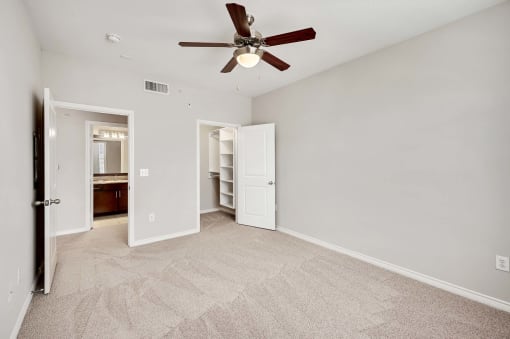 a bedroom with a ceiling fan and a closet
