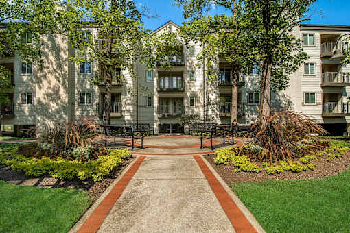 A pathway leads to a building with a green lawn on either side.