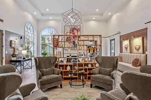 A living room with a brown sofa and a wooden bookshelf.