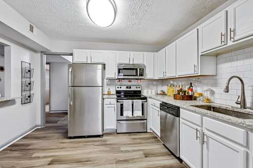 A kitchen with white cabinets and stainless steel appliances.
