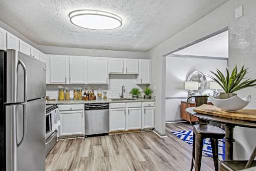 A kitchen with white cabinets and a refrigerator.