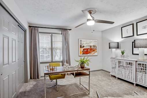 A room with a table, chairs, and pictures on the wall.