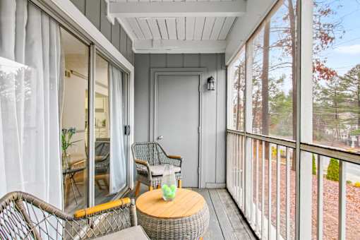 A balcony with a table and chairs is shown.