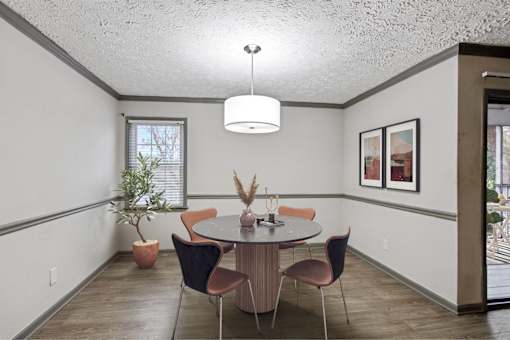 A dining room with a round table and chairs.