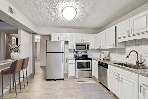 A kitchen with white cabinets and stainless steel appliances.