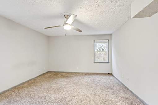A room with a ceiling fan and a window.