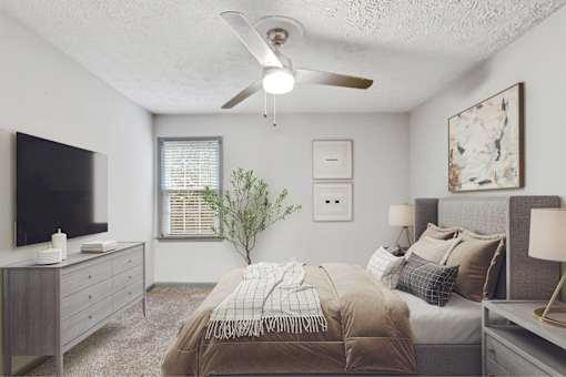 A bedroom with a bed, a dresser, a television, and a window with blinds.