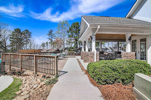 A house with a covered patio and a stone wall.