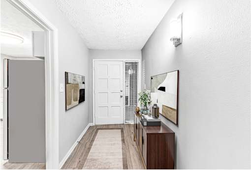 A hallway with a white door and a brown cabinet.