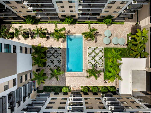 A pool surrounded by greenery in a modern building.