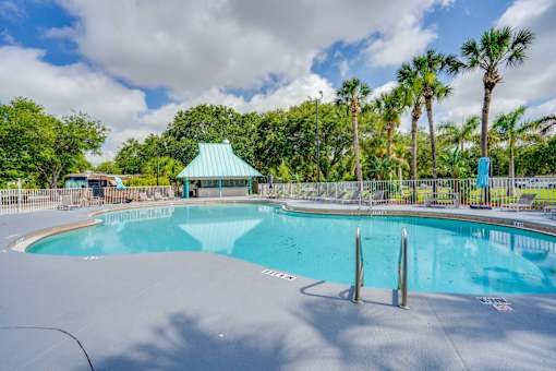 a resort style pool with palm trees and a gazebo