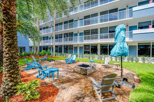 a patio with chairs and an umbrella outside of a building