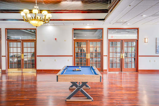 a games room with a pool table and a chandelier