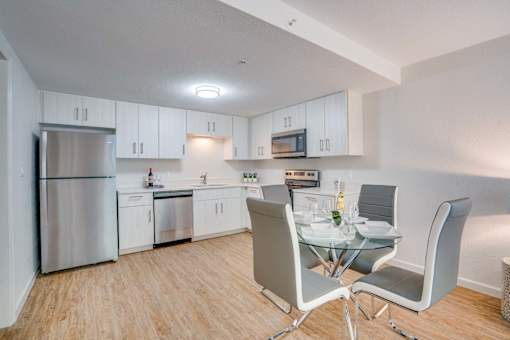 our modern kitchen and dining room with white cabinets and stainless steel appliances