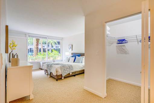 a bedroom with a bed and a closet      and a window