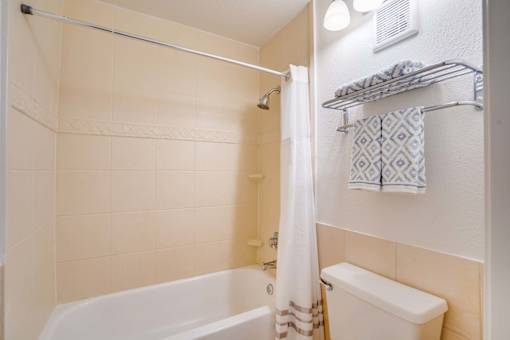 a bathroom with a shower and a toilet and a tub