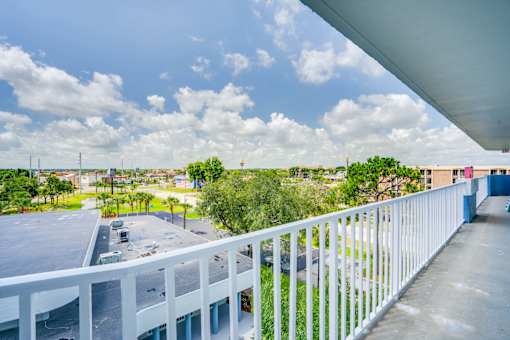 the view from the balcony of a condo overlooking a parking lot and the city