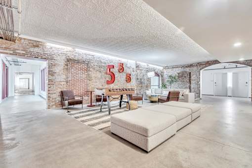 A large, open room with a brick wall and a white couch.
