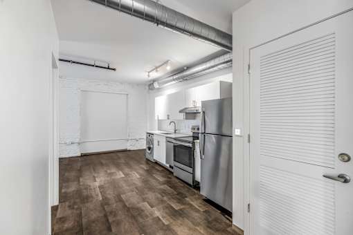 A kitchen with a refrigerator, oven, and sink.