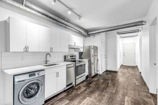 A modern kitchen with white cabinets and stainless steel appliances.