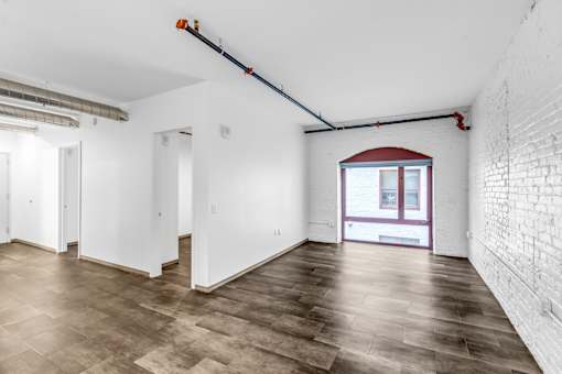 A room with white walls and a wooden floor.