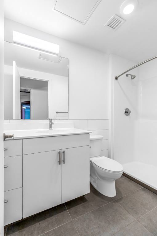 A white bathroom with a toilet, sink, and mirror.