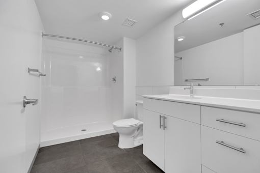 A white bathroom with a toilet, sink, and shower.