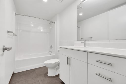 A white bathroom with a toilet, sink, and bathtub.