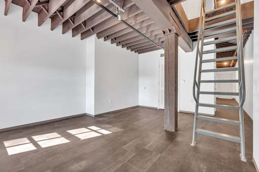 A room with a wooden floor and a metal staircase.