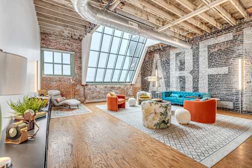 A modern living room with a brick wall and a large window.