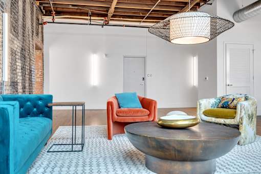 A living room with a blue couch, a red chair, and a coffee table.