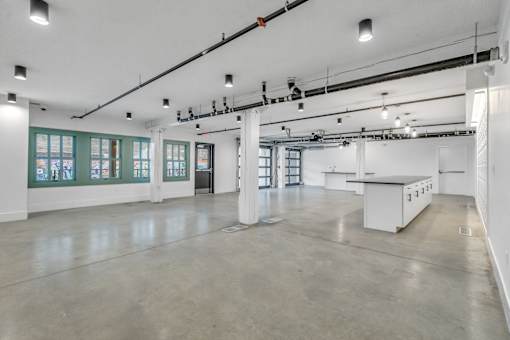 A large, empty room with white walls and a concrete floor.