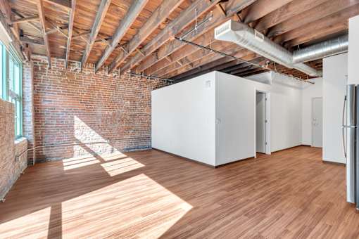 A room with wooden floors and a brick wall.