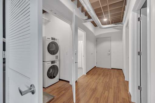 A laundry room with a washer and dryer stacked on top of each other.