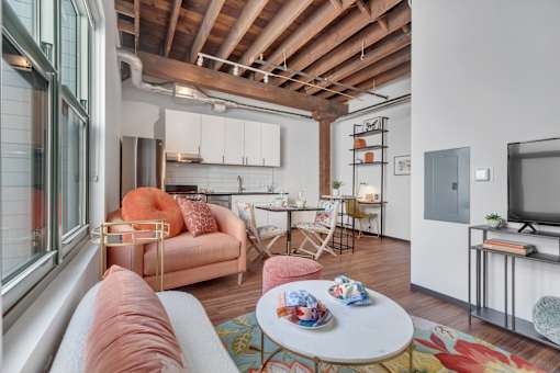 A living room with a couch, chairs, and a television.