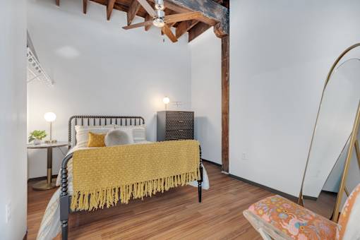 A bedroom with a bed covered in a yellow blanket.