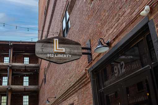 A sign for 912 Liberty is hanging from a building.