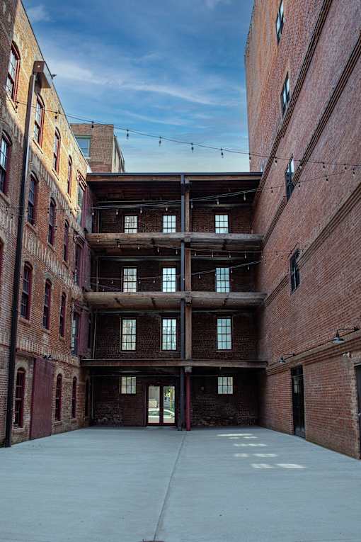 A large open courtyard surrounded by brick buildings.