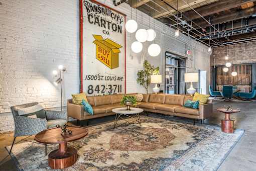 A living room with a large sofa and a coffee table in front of a large poster.