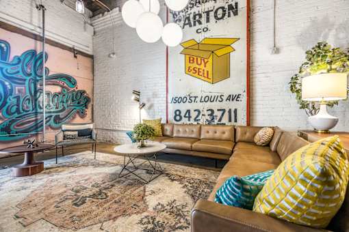 A living room with a brown couch and a rug.