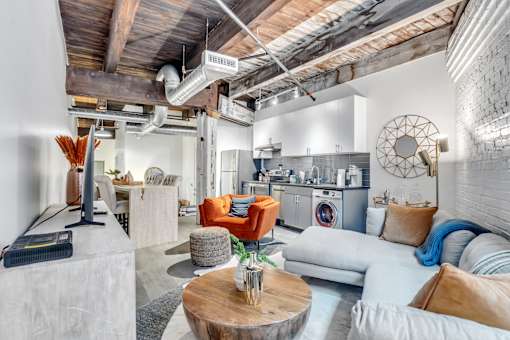 A living room with a white couch and a wooden coffee table.