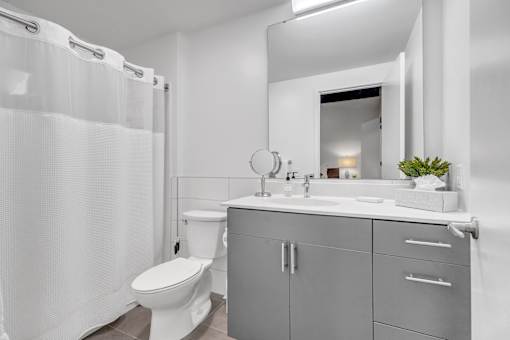 A white toilet sits next to a sink in a modern bathroom.
