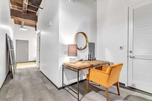 A room with a wooden table and a yellow chair.