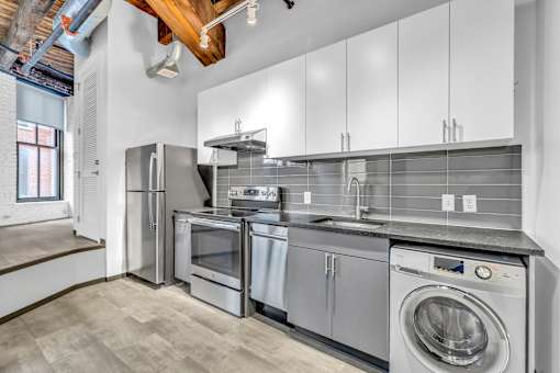 A modern kitchen with stainless steel appliances and white cabinets.